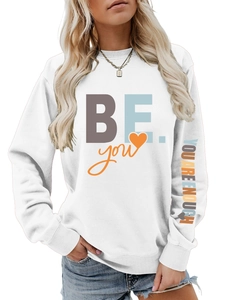 Détail de l'imprimé 'YOU ARE ENOUGH' sur la manche d'un sweat blanc à manches longues