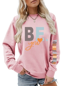 Détail du sweat rose avec le slogan 'YOU ARE ENOUGH' imprimé sur la manche longue