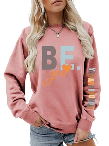 Détail du sweat-shirt rose avec imprimé BE YOU YOU ARE ENOUGH sur le bras et col rond