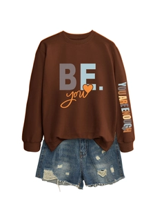 Pull marron avec imprimé sur la manche et short en jean bleu délavé à plat