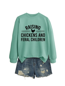 Détail du sweat-shirt vert menthe avec imprimé poulet et short en jean vieilli