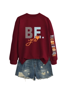 Détail du sweat-shirt bordeaux imprimé BE YOU et du short en jean vieilli