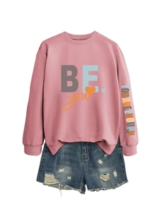 Détail du sweat rose et short en jean avec texte YOU ARE ENOUGH sur la manche gauche