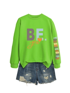 Détail du sweat vert clair avec imprimé YOU ARE ENOUGH sur la manche et short denim
