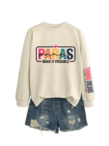 Flat lay of cream crewneck sweatshirt with colorful PARAS print and ripped denim shorts