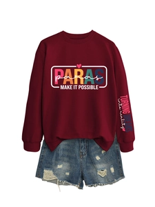 Flat lay of burgundy sweatshirt with colorful PARAS print and distressed denim shorts