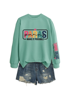 Close-up of mint green sweatshirt with PARAS logo print and distressed denim shorts