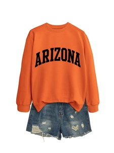 Detailed flat lay of orange Arizona sweatshirt paired with distressed denim shorts