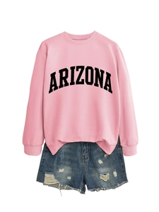 Flat lay of pink Arizona sweatshirt paired with distressed blue denim shorts on white background