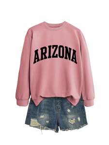 Flat lay of pink Arizona sweatshirt paired with distressed denim shorts on white background