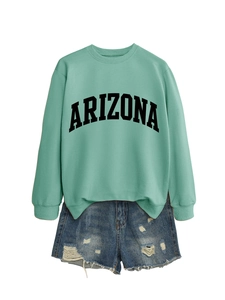 Detail of mint green Arizona sweatshirt with ribbed cuffs and frayed denim shorts
