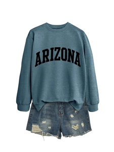 Flat lay of blue Arizona crewneck sweatshirt with distressed ripped denim shorts