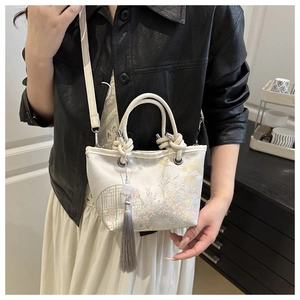 Gros plan sur la broderie en soie et le long gland élégant sur un sac seau blanc chic
