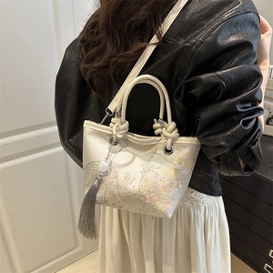 Sac seau brodé de style chinois avec motifs floraux et détail de pompon en soie
