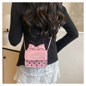 Detailed back view of pink bow polka dot bag worn with lace skirt and black top