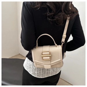 Vue arrière du modèle portant un sac bandoulière crème avec boucle dorée élégante