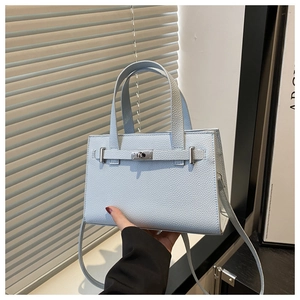 Close-up of light blue pebble leather tote bag with silver metal lock and top handles
