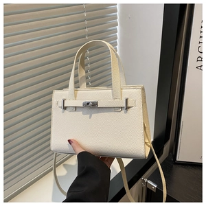 Detail of cream lychee texture leather handbag featuring silver metal twist lock closure