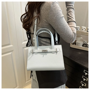 Detail of light blue lychee pattern leather handbag with metal turn-lock and handle