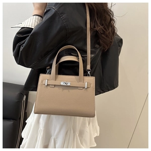 Beige lychee texture leather bag shown on model with adjustable shoulder strap details