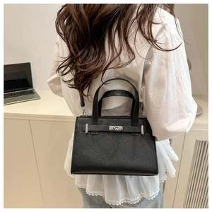 Detail of black lychee grain leather handbag featuring silver metal clasp and buckle