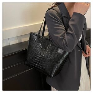 Detail shot of black crocodile texture pattern on a large faux leather tote bag