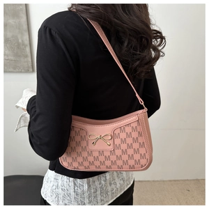 Detail of pink crescent bag with M-pattern monogram and gold bow metal buckle