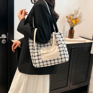 Borsa tote in tweed a contrasto con tasca bianca indossata da una modella