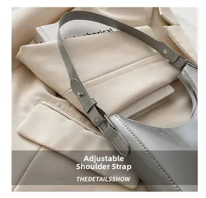 Detail of adjustable strap with metal studs on silver crescent underarm bag