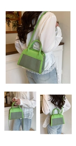Detail view of grass green shell bag with herringbone fabric panels and metal hardware
