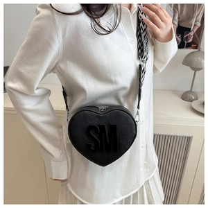 Detail of heart-shaped crossbody bag with bold SM lettering and patterned strap