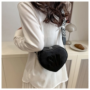 Detail of heart-shaped black crossbody bag with SM letter and geometric strap