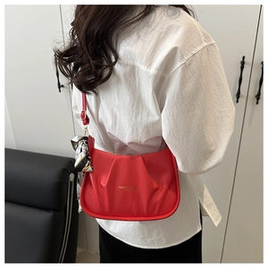 Détail du sac croissant rouge avec foulard en soie et texte mode sur le cuir