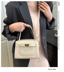 Detail view of cream tote bag featuring cross-grain texture and golden twist lock closure