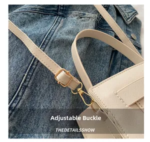 Detail of adjustable gold buckle and lobster clasp on white Saffiano leather strap