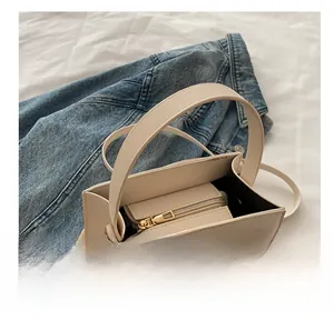 Detail of cream square handbag showing inner zip compartment and textured crossgrain leather