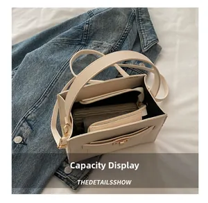 Interior capacity display of cream faux leather crossbody bag with golden twist lock