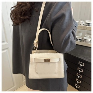 Close-up of a white Saffiano leather crossbody bag with metal lock and adjustable strap