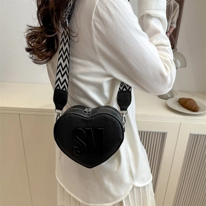 Fashionable heart-shaped crossbody bag in black leather with wide chevron strap
