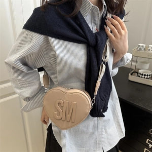 Fashionable beige heart-shaped crossbody bag with embossed SM letters and crossgrain texture