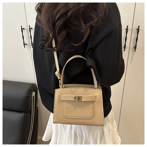 Beige Saffiano leather tote with metallic twist lock shown on a model for scale