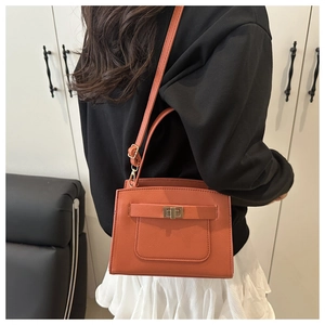 Orange crossgrain leather Kelly handbag with metal buckle closure shown on model