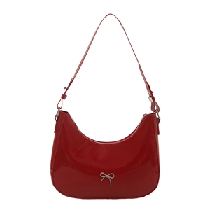 Glossy red patent leather underarm bag with silver bow accent and adjustable shoulder strap