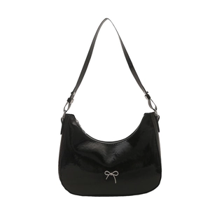 Minimalist black patent leather baguette bag with silver metal bow detail