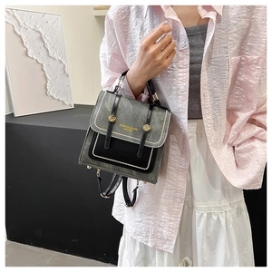 Detail of grey and black patchwork handbag with gold studs and white bead trim