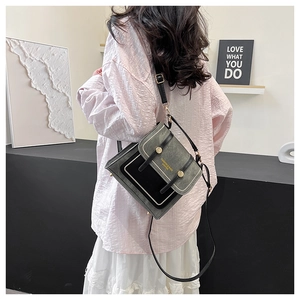 Detailed view of vintage patchwork crossbody bag with metallic accents and stylish branding