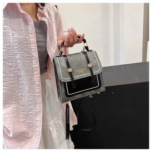 Detail of vintage gray and black panelled bag with pearl trim and gold metal hardware