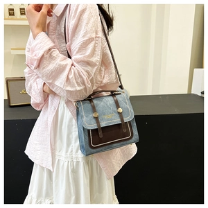 Detail view of denim and brown leather crossbody bag with FASHION & BAGS branding