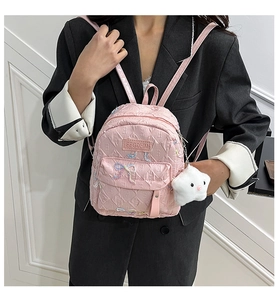 Pink mini quilted backpack with bow detail and star charm shown on a model's back