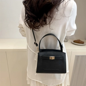 Classic black lychee textured handbag with gold twist lock for elegant daily commute